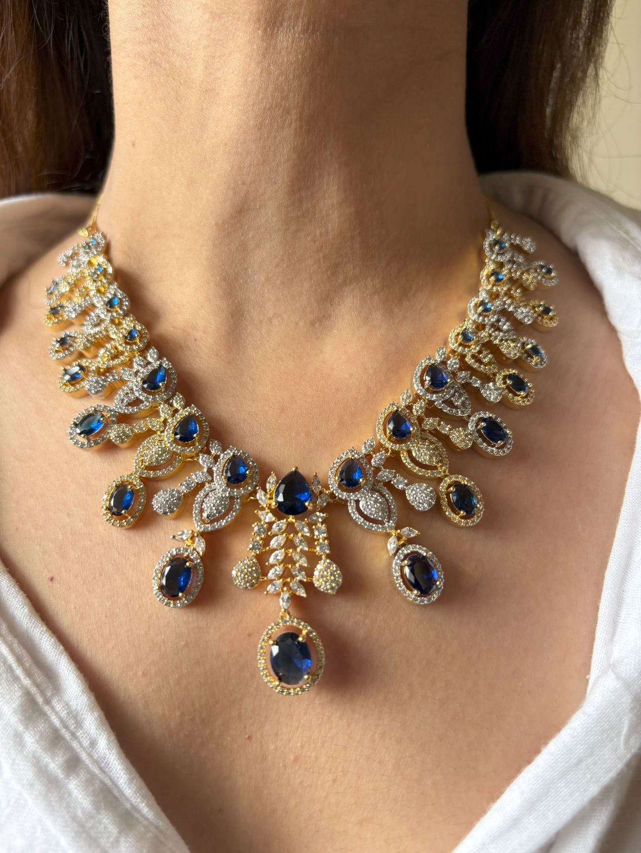 Shop Royal Sapphire Stone Heavy Necklace In AD With Gold & Rhodium Plating online in India. Explore elegant bridal AD jewellery online. Shop premium bridal jewellery sets in Zircon, AD, Kundan, Victorian Diamond. Collection best suited for Indian weddings, parties and special occasions. Choose AD Necklace in blue stone for sarees, lehengas and gowns. -front
