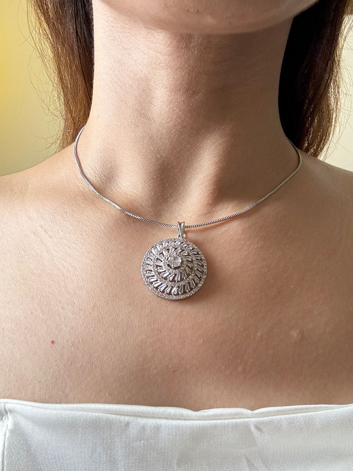 Shop Kiara Round Pendant Set With Studs In AD Online in India. Pendant sets in different stones like Kundan, Moissanite, CZ stones and AD stones in all kinds quality are available online for purchase on website. Explore pendant sets for festive occasions perfect mothers and elderly ladies too. Pendant sets in green, blue, pink, red and white stones are available for wearing with sarees, lehengas, suits and Indo-westerns. -side