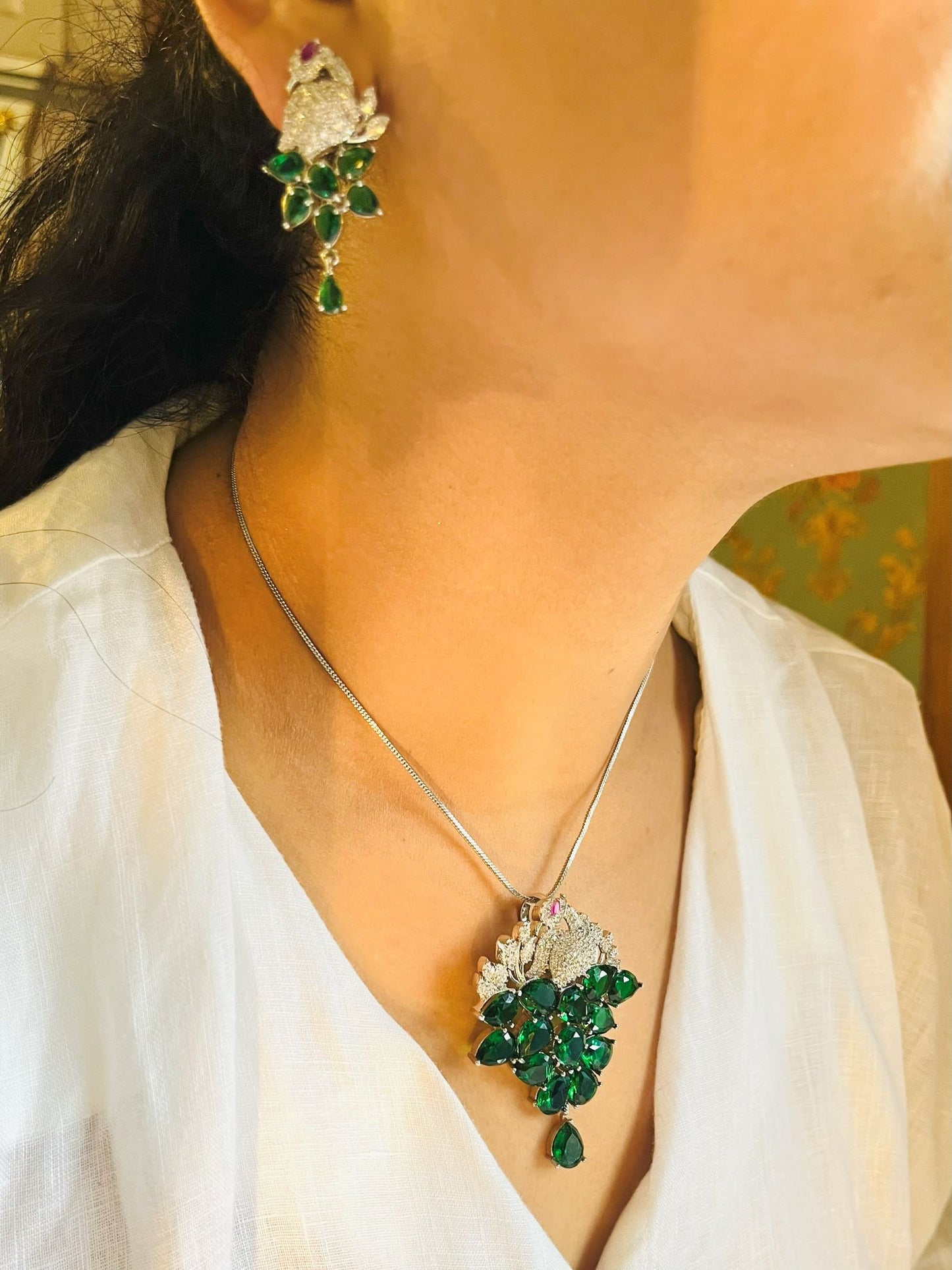 Shop Morni Pendant Set In Green Doublet & AD Stones Online in India. Pendant sets in different stones like Kundan, Moissanite, CZ stones and AD stones in all kinds quality are available online for purchase on website. Explore pendant sets for festive occasions perfect mothers and elderly ladies too. Pendant sets in green, blue, pink, red and white stones are available for wearing with sarees, lehengas, suits and Indo-westerns. -withearrings