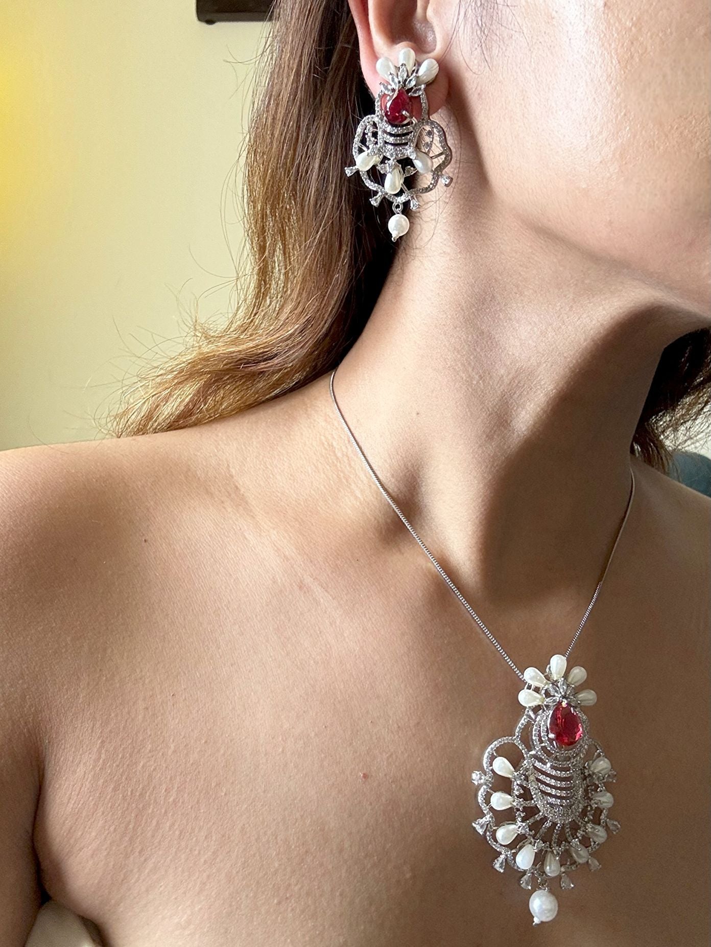 Shop Ruby Love Floral Pendant Set In AD & Pearls Online in India. Pendant sets in different stones like Kundan, Moissanite, CZ stones and AD stones in all kinds quality are available online for purchase on website. Explore pendant sets for festive occasions perfect mothers and elderly ladies too. Pendant sets in green, blue, pink, red and white stones are available for wearing with sarees, lehengas, suits and Indo-westerns. -withearrings