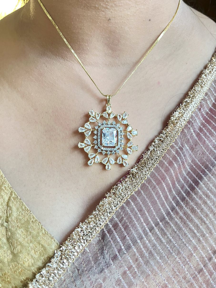 Shop Rekha Floral Pendant Set With Studs In Gold Polish Online in India. Pendant sets in different stones like Kundan, Moissanite, CZ stones and AD stones in all kinds quality are available online for purchase on website. Explore pendant sets for festive occasions perfect mothers and elderly ladies too. Pendant sets in green, blue, pink, red and white stones are available for wearing with sarees, lehengas, suits and Indo-westerns. -front