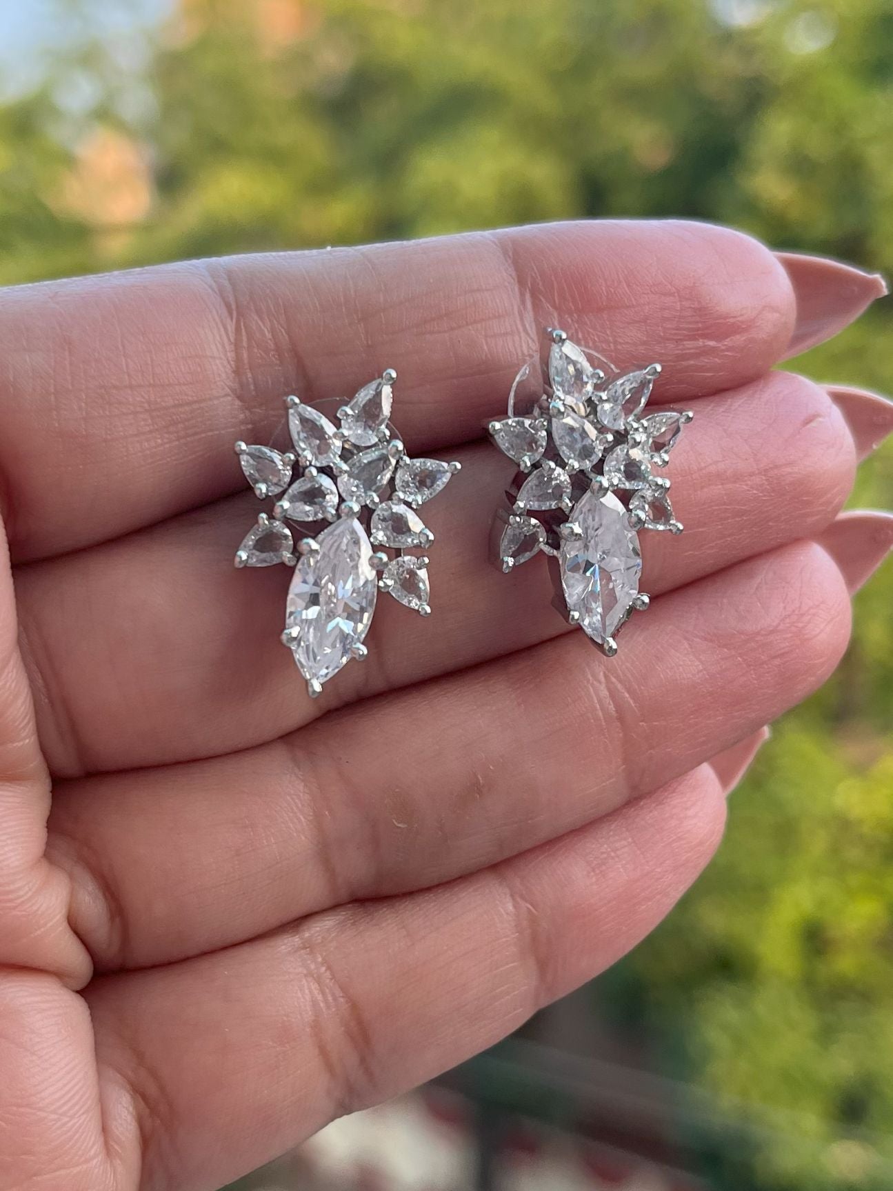 Shop Floral Studs Earrings In CZ Stones Rhodium Polish online in India. Shop from an exclusive range of zircon jewellery, Indian wedding jewelry, gold plated earrings, rhodium plated jewellery, AD earrings, AD necklace sets for weddings, engagements and parties. -front