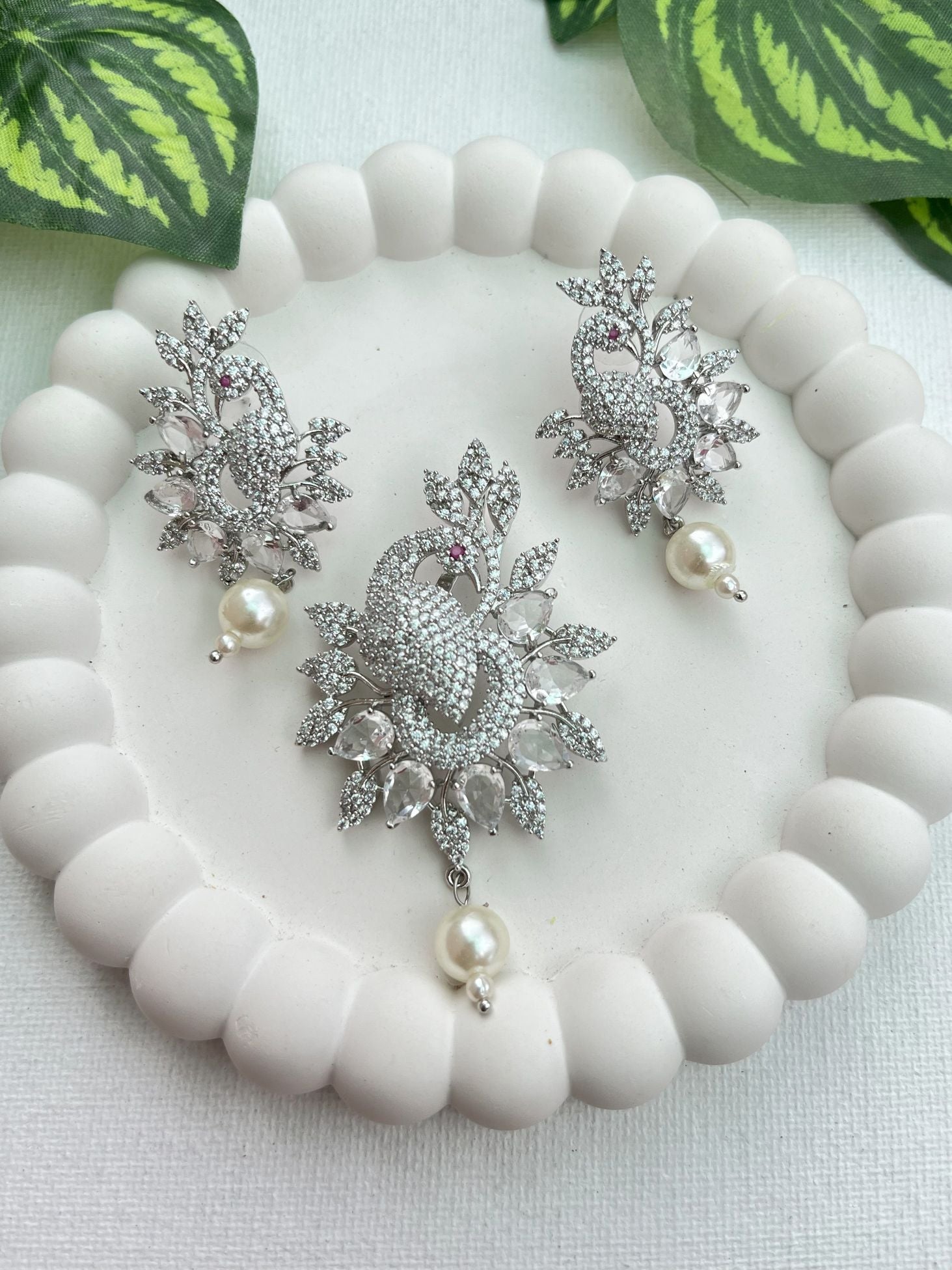 Shop Peacock Shaped Diamond Look Pendant Set In AD Online in India. Pendant sets in different stones like Kundan, Moissanite, CZ stones and AD stones in all kinds quality are available online for purchase on website. Explore pendant sets for festive occasions perfect mothers and elderly ladies too. Pendant sets in green, blue, pink, red and white stones are available for wearing with sarees, lehengas, suits and Indo-westerns. -withearrings