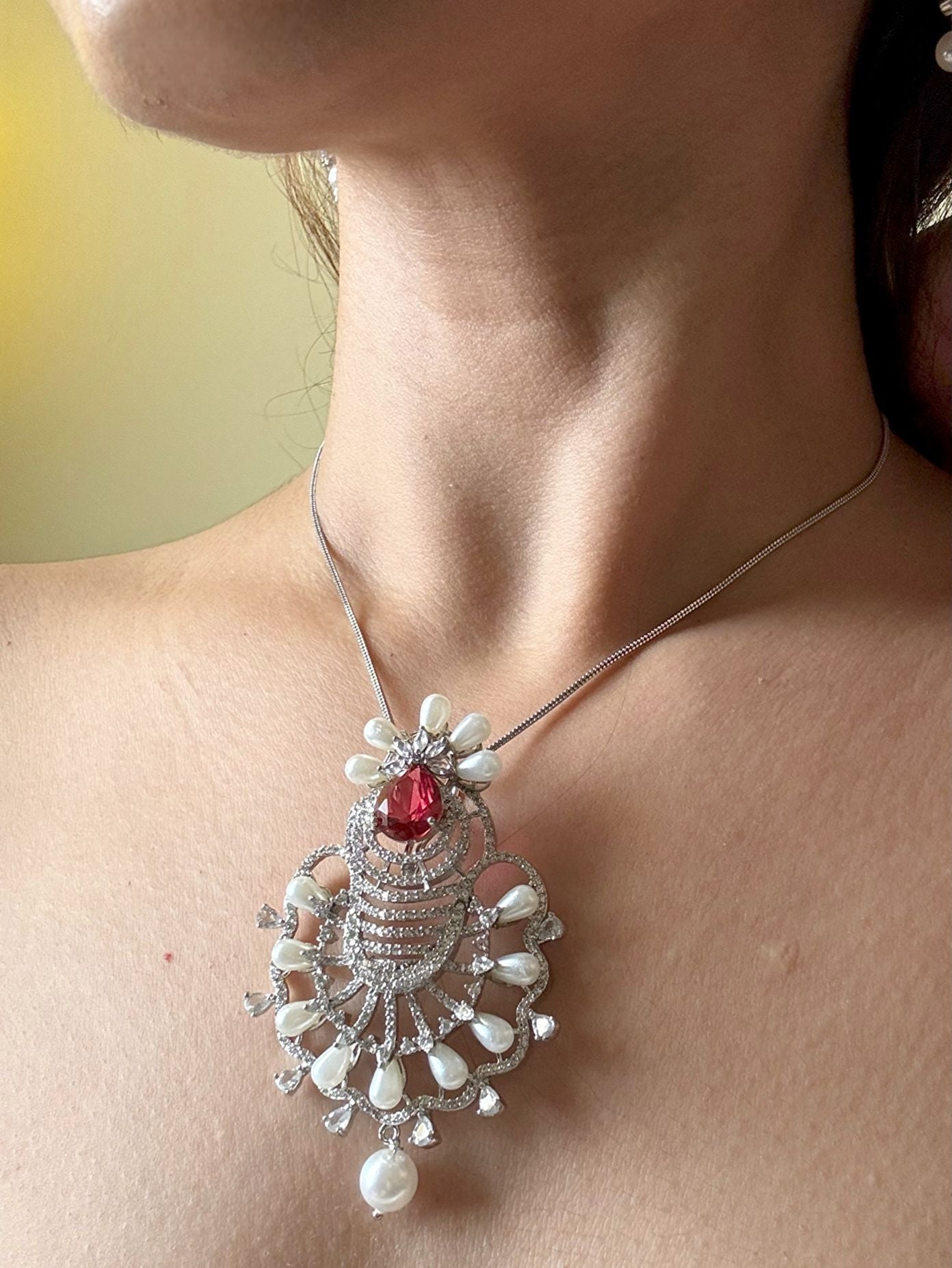 Shop Ruby Love Floral Pendant Set In AD & Pearls Online in India. Pendant sets in different stones like Kundan, Moissanite, CZ stones and AD stones in all kinds quality are available online for purchase on website. Explore pendant sets for festive occasions perfect mothers and elderly ladies too. Pendant sets in green, blue, pink, red and white stones are available for wearing with sarees, lehengas, suits and Indo-westerns. -side